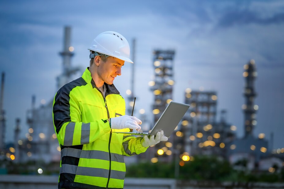 Fachkraft überwacht Sicherheitsstandards in Industrieanlage mithilfe digitaler Dokumentation – moderner Arbeitsschutz in München